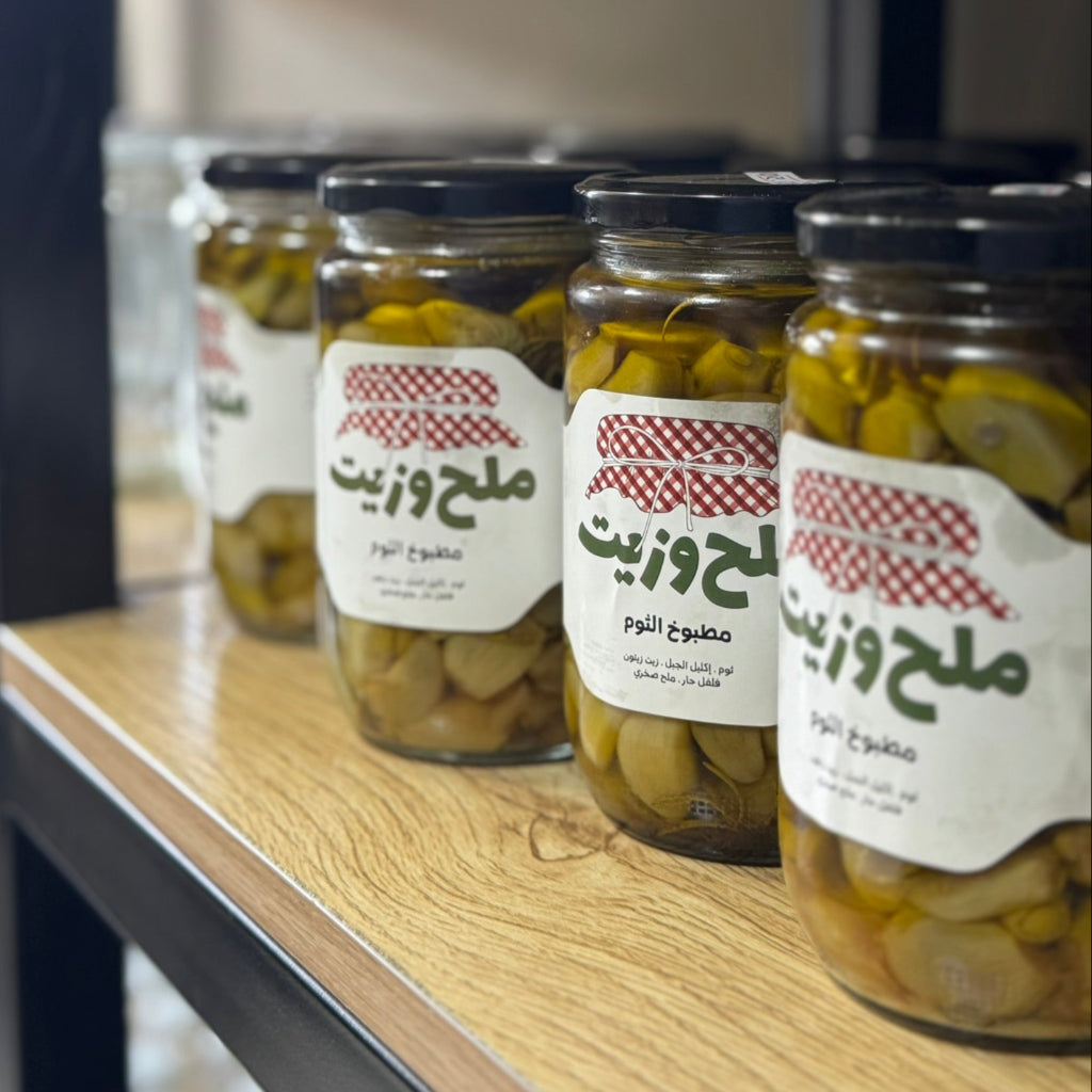 مجموعة من المرطبانات الزجاجية تحتوي على مطبوخ الثوم بزيت الزيتون