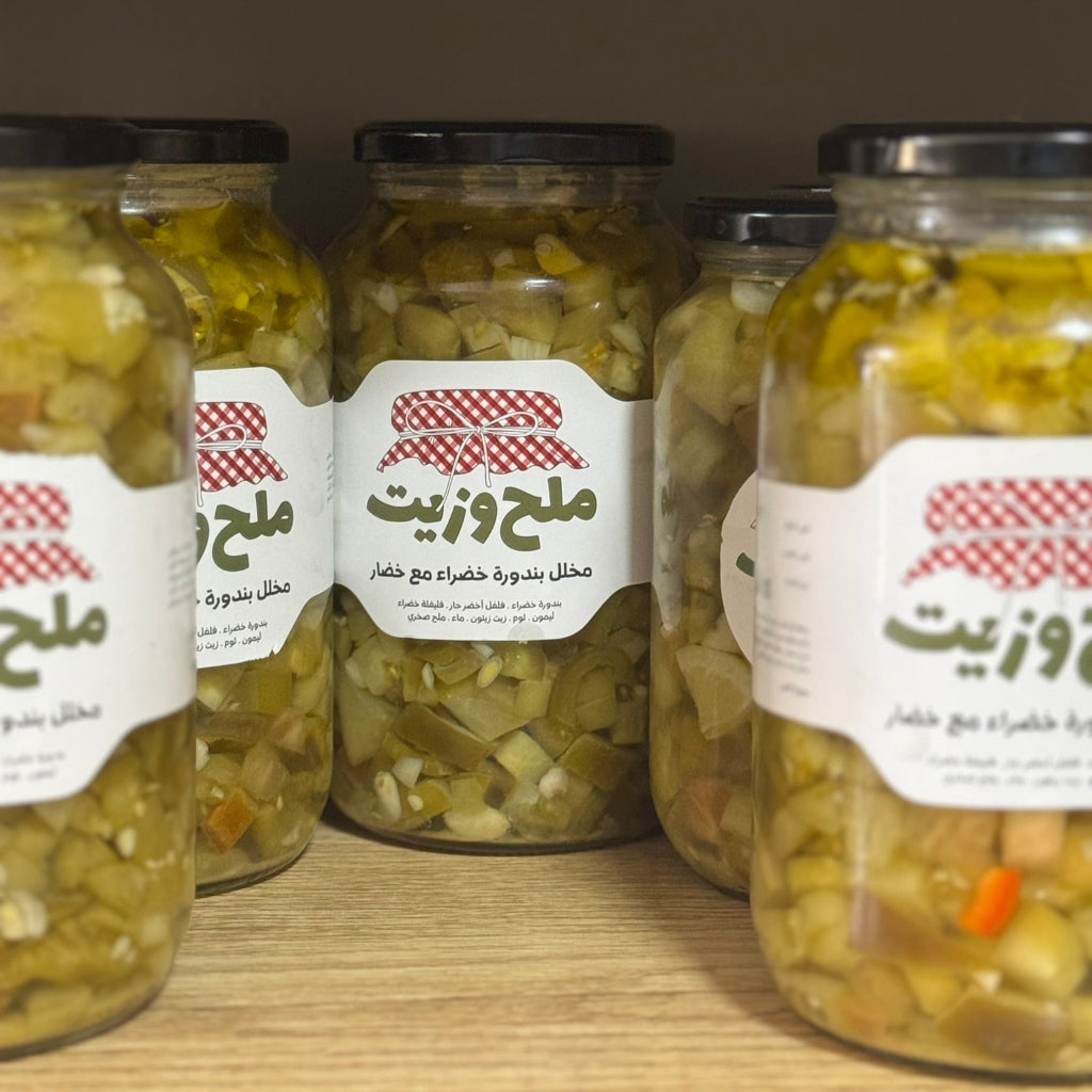 مجموعة من المرطبانات الزجاجية تحتوي على مخلل بندورة خضراء مع الخضار