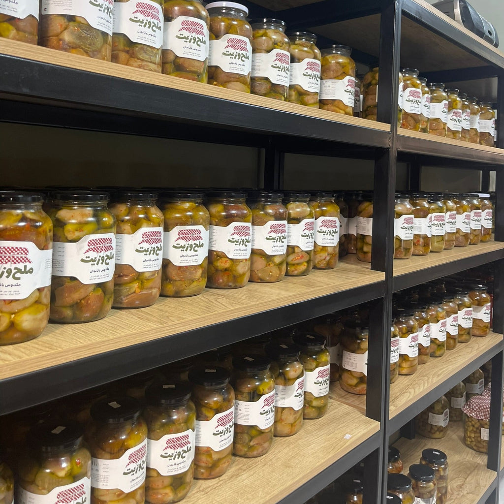 صورة داخلية لمتجر ملح وزيت للمؤن التقليدية تظهر مجموعة من المرطبانات الزجاجية التي تحتوي على مكدس الباذنجان الحمصي