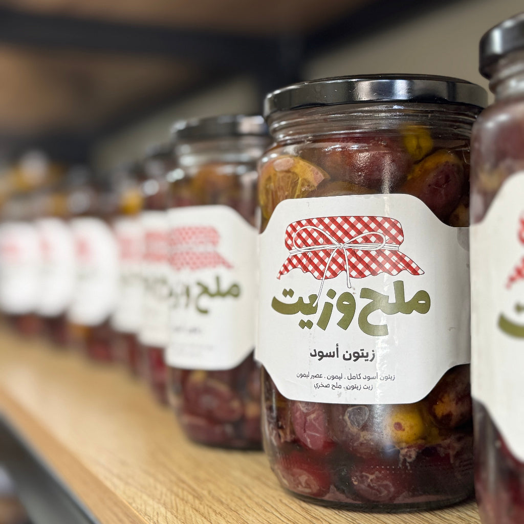 مجموعة من المرطبانات الزجاجية تحتوي على زيتون أسود بالزيت